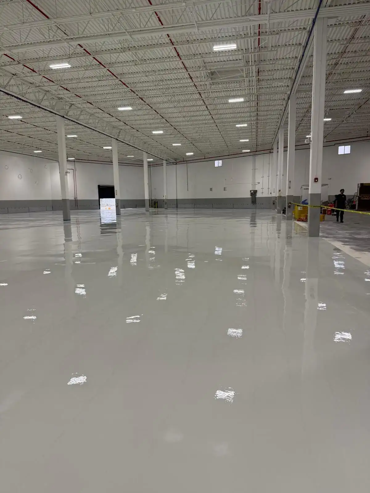 Glossy light gray epoxy floor in an industrial warehouse, South Florida